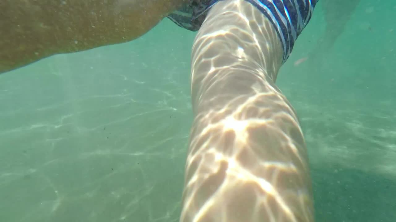 vista alta de un niño caucásico nadando con una tabla de natación y buceando bajo el agua 60fps
