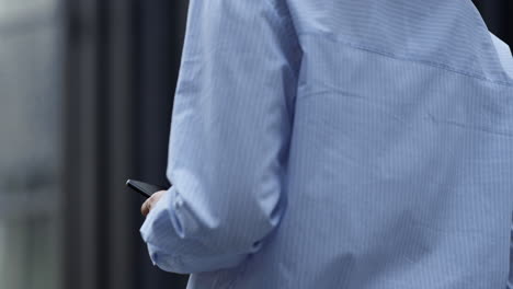 Closeup-hands-hold-smartphone-at-downtown-area.-Social-networking-outdoor