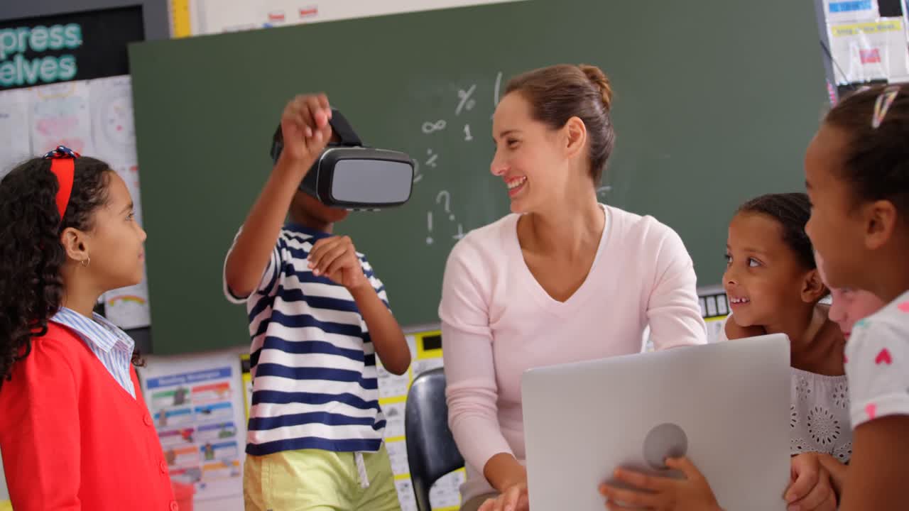 Front view of African american schoolboy using virtual reality headset with teacher and classmates i