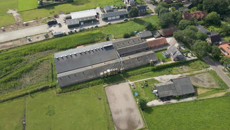 Stunning-aerial-of-large-farm-building-at-the-edge-of-rural-town