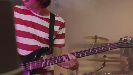 young musician playing electric guitar in recording studio