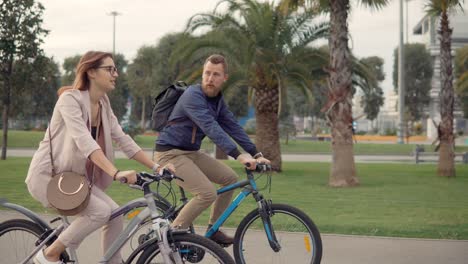 couple cycling in city park