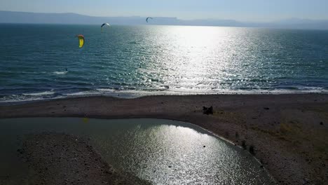 Drone-footage-flying-over-a-beach-in-the-Sea-of-Galilee-showing-kite-surfers