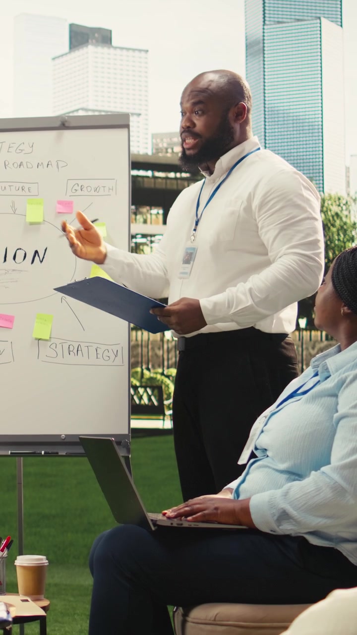 Vertical Video Diverse business people explaining vision implementation with sticky notes
