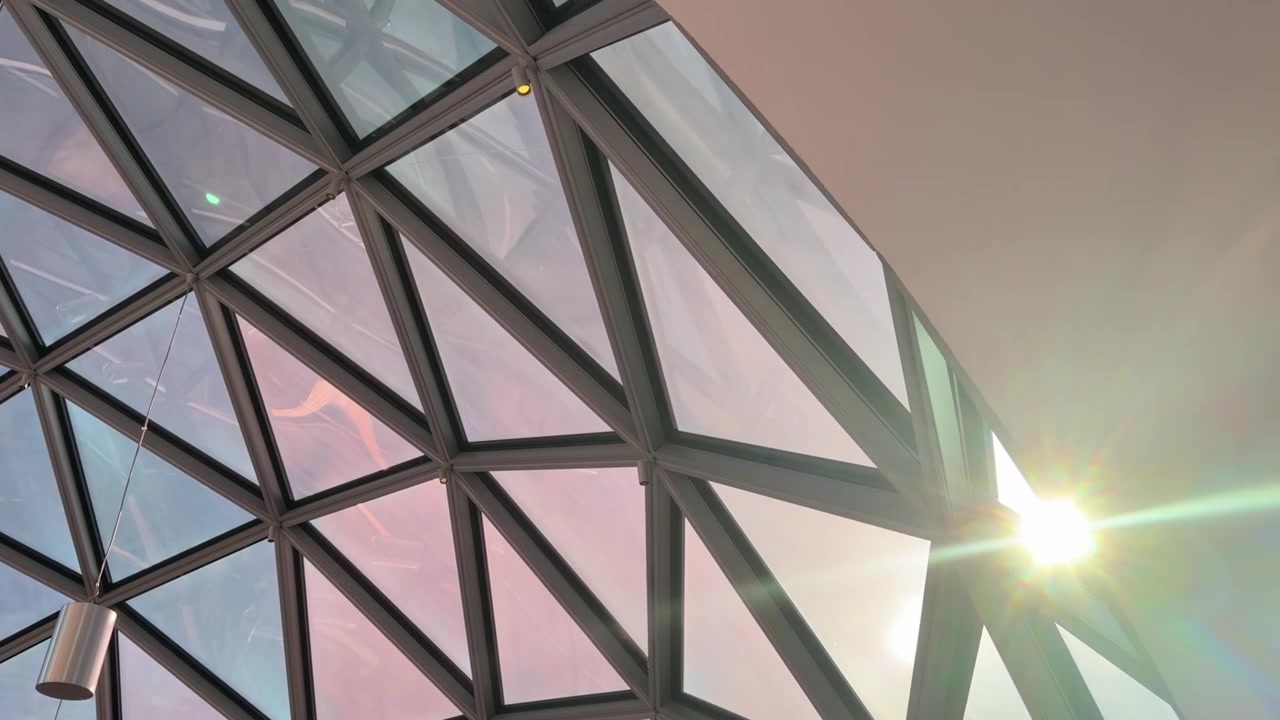 Sunlight shines through geometric glass dome ceiling with modern architectural design