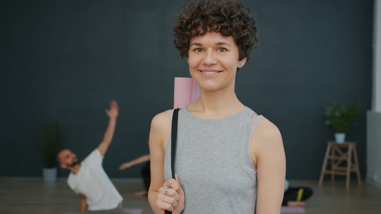 Yoga instructor in studio with yoga mat