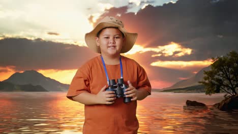 asian boy with a hat clapping hands after looking through the binoculars. boy researcher examines something at a lake, travel tourism adventure concept