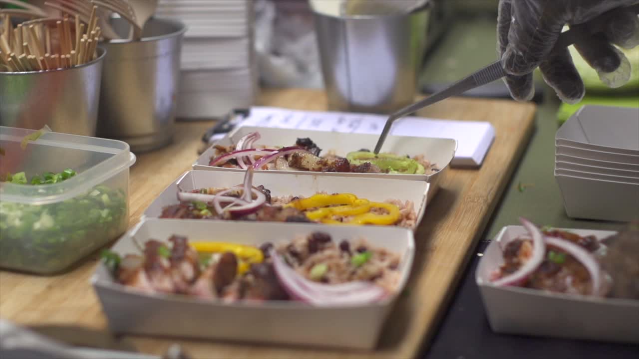 pimienta verde recogida y colocada con una pinza en una caja de almuerzo de barbacoa, filmada en cámara lenta