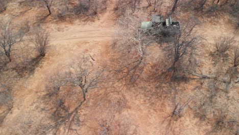 Expedition-truck-drives-along-a-winding-dirt-road-in-the-Kalahari-Desert-in-Chobe-National-Park