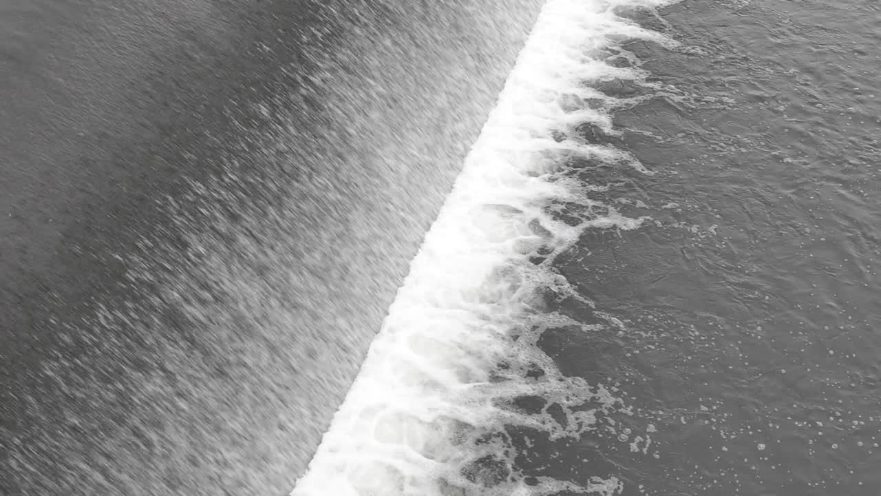 Abstract view of weir with a water falling down and making foam