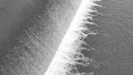 abstract view of weir with a water falling down and making foam