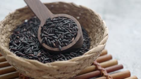 black rice in wooden spoon and bowl