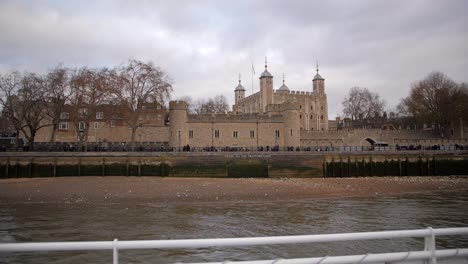 vista de la torre de londres desde un barco en el támesis