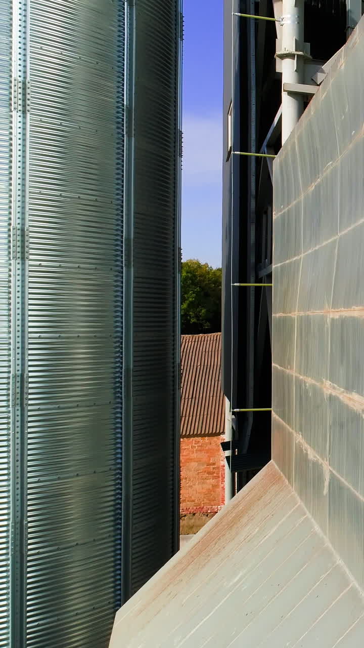 Storage and drying of cereals. Aerial drone view of agricultural silos. Vertical video