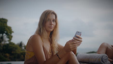 woman using phone by the pool