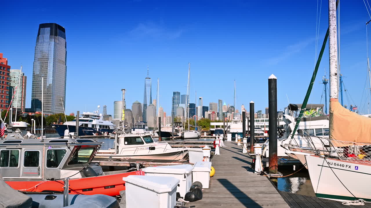 New Jersey, USA, 19 August 2025: Walking by the wooden berth with boats and yachts nearby. Yacht club in Jersey City, USA. Manhattan skyline at backdrop