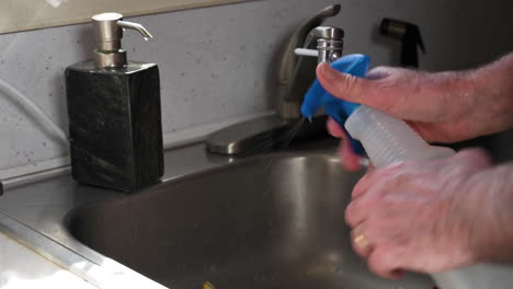 man hands cleaning surfaces by spraying alchohol and rubbing towel - closeup shot