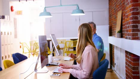 ejecutivos de negocios hablando mientras trabajan en la computadora