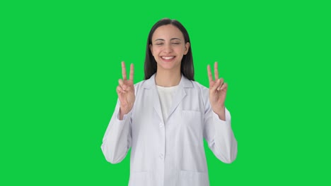 Happy-Indian-female-scientist-showing-victory-sign-Green-screen