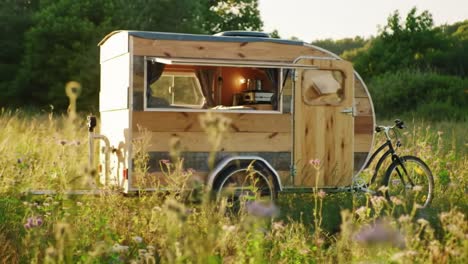 charming wooden caravan in serene meadow, nestled amidst wildflowers and greenery, perfectly captured in natural light during golden hour