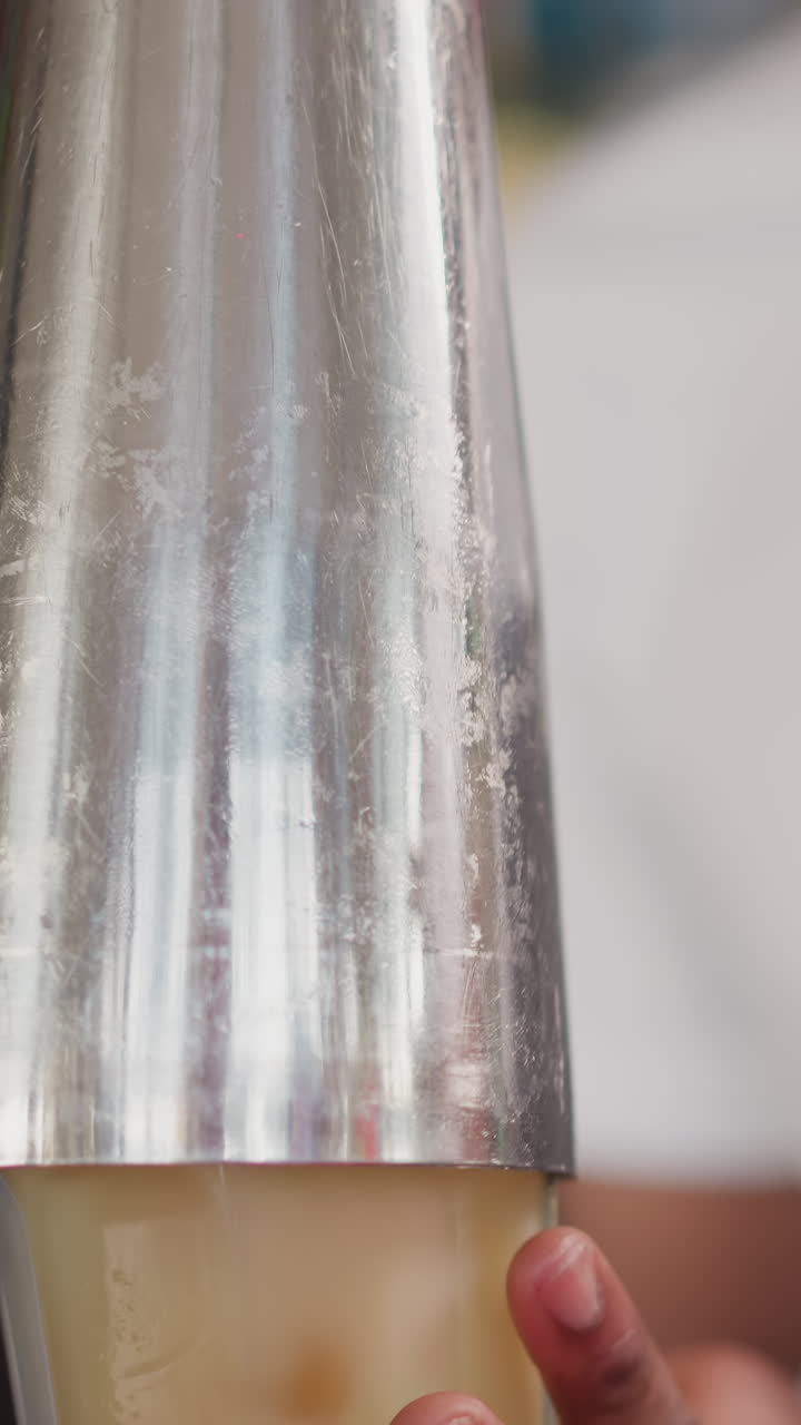 el camarero vierte un cóctel en un vaso de un agitador en un bar de primer plano. el camarero afroamericano sirve bebidas alcohólicas en un club nocturno. el hombre negro prepara una bebida