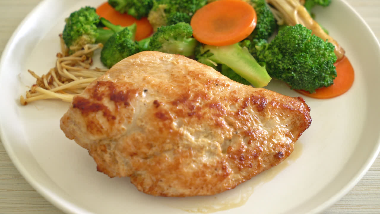 filete de pollo a la parrilla con verduras en un plato blanco