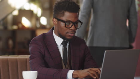African American Businessman Working on Laptop in Cafe