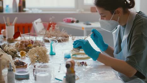 woman creating resin art with dried flowers