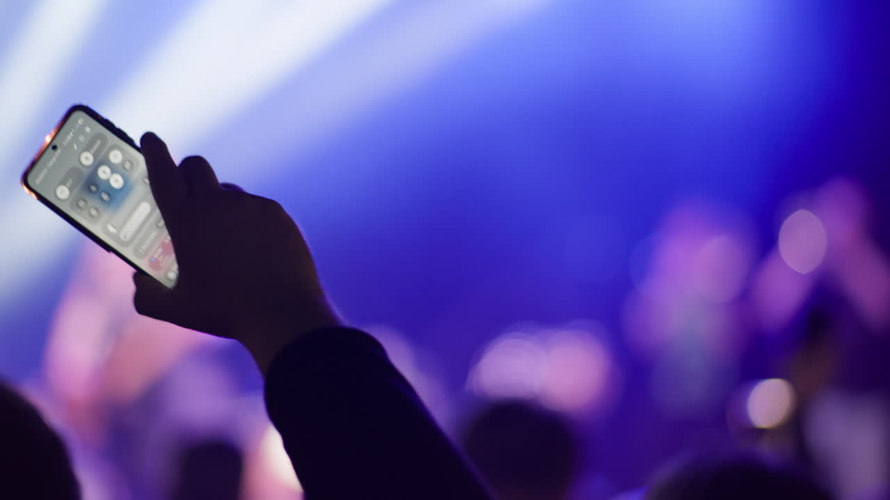 Mano che Registra con Smartphone a un Vibrante Concerto dal Vivo