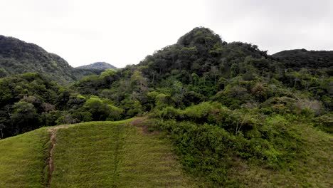 tree covered ancient hills at valle de anton volcanic crater in central panama, aerial flyover shot