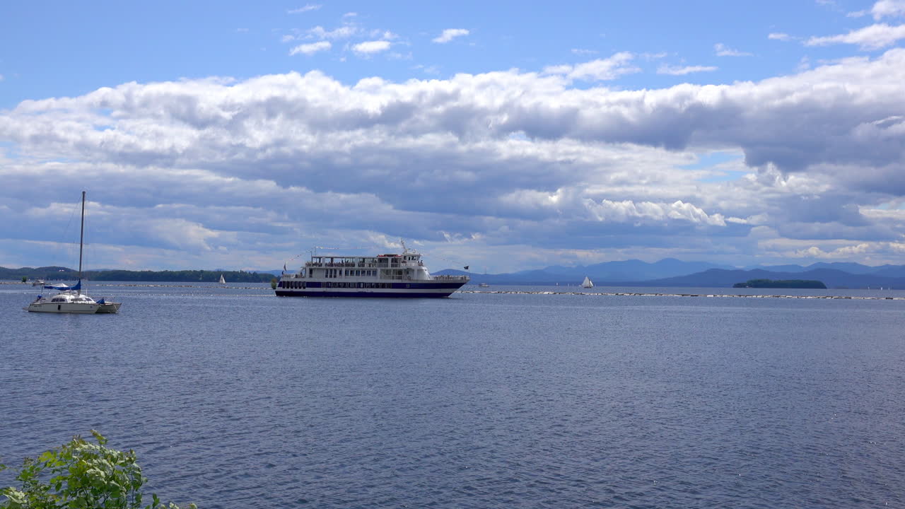 A tourist cruise boat passes a jetty on Lake Champlain
