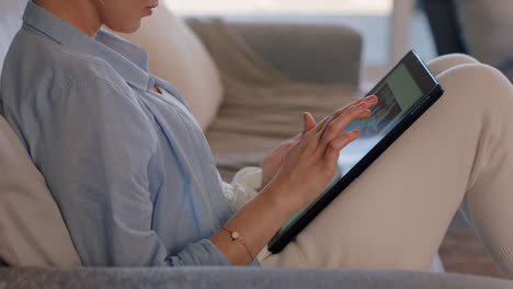 mujer joven usando una tableta digital relajándose en el sofá en casa navegando en línea leyendo correos electrónicos disfrutando de compartir un estilo de vida cómodo en las redes sociales