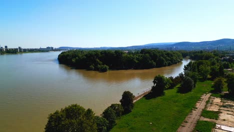 lush vegetation and tranquil river in obuda island, budapest, hungary - aerial drone shot