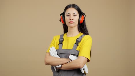 serious woman constructor in safety gear with folded arms