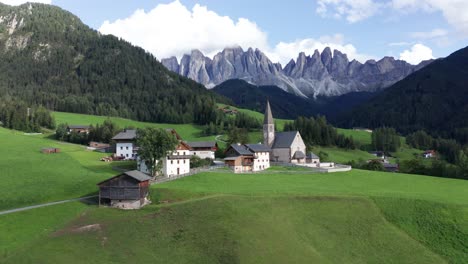 Small-village-in-Val-Di-Funes-mountain-valley,-Dolomites-Italy-aerial-orbit