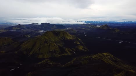 Aerial-landscape-view-of-Icelandic-highlands,-dark-mountains-with-green-peaks,-on-a-cloudy-day