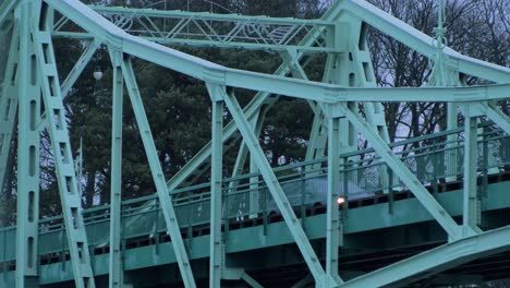 Cars-driving-over-the-Oskara-Kalpaka-metal-swing-bridge-at-Karosta-in-cloudy-afternoon,-medium-shot