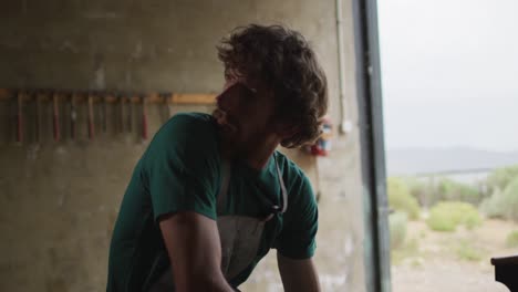 un herrero caucásico cansado descansando en el taller
