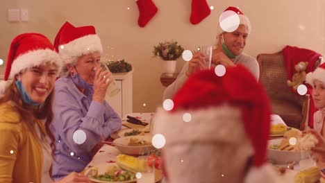 animación de nieve cayendo sobre una feliz familia caucásica durante la cena de navidad