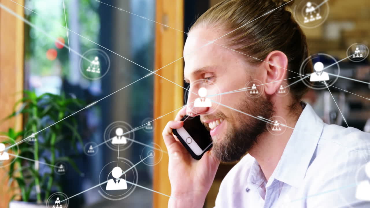 Homme barbu parlant au smartphone dans un salon de bureau moderne, avec des icônes de réseau technologique animées