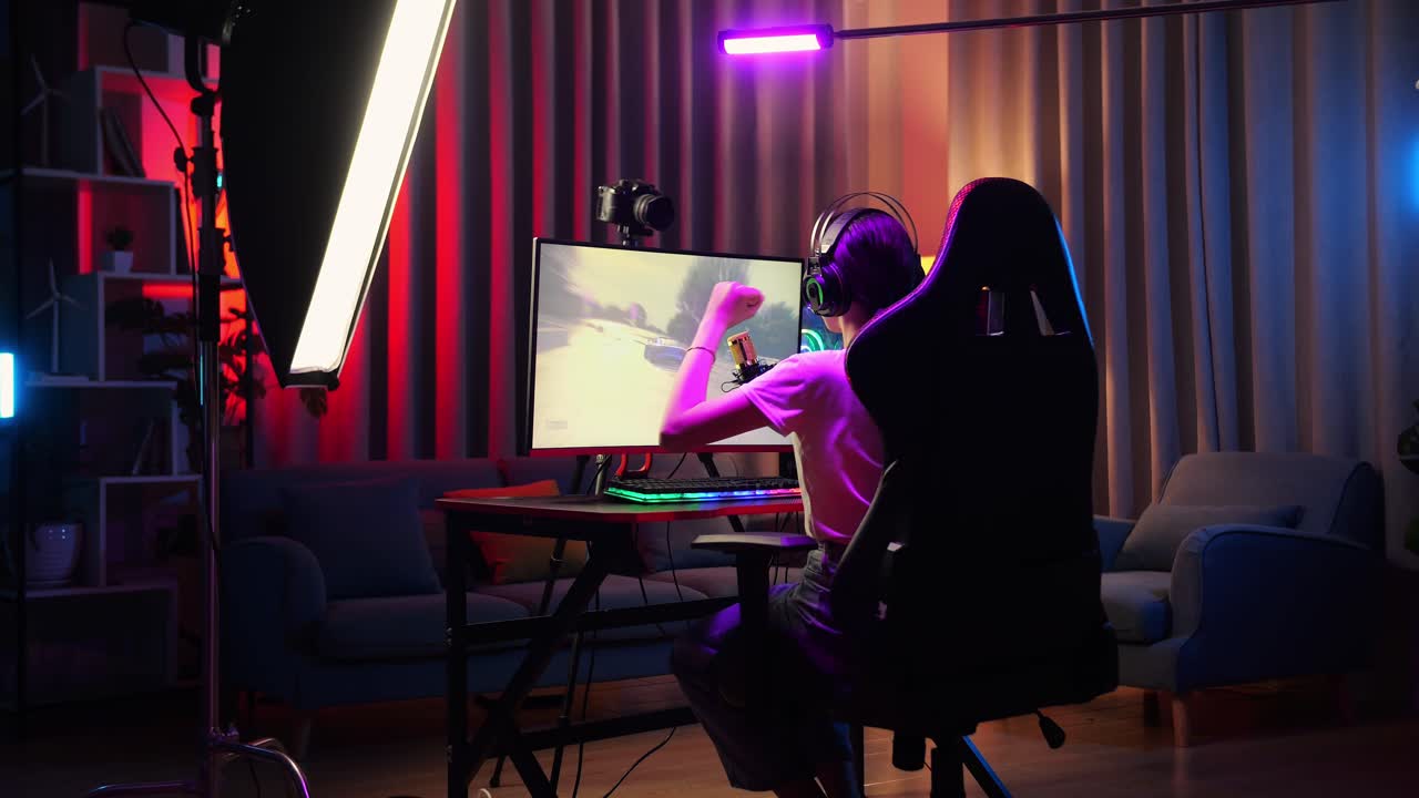 vista trasera de la chica asiática streamer gritando gol celebrando el juego de carreras de coches ganador a través de la red en la computadora personal. videojuego de transmisión en vivo, escritorio iluminado por luz de tira de led rgb