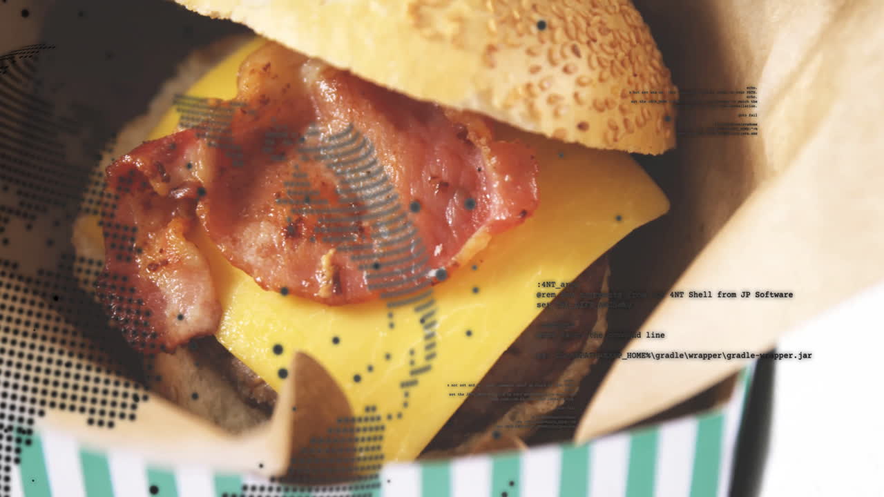 Cheeseburger with bacon and sesame bun overlaid with coding text animation