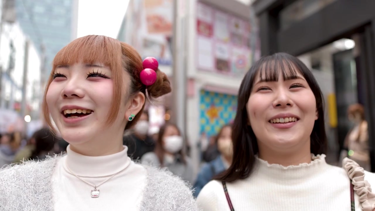 街中で笑顔で周りを見回す若い日本人女性2人