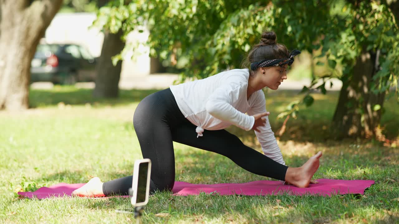una adolescente haciendo yoga en el parque