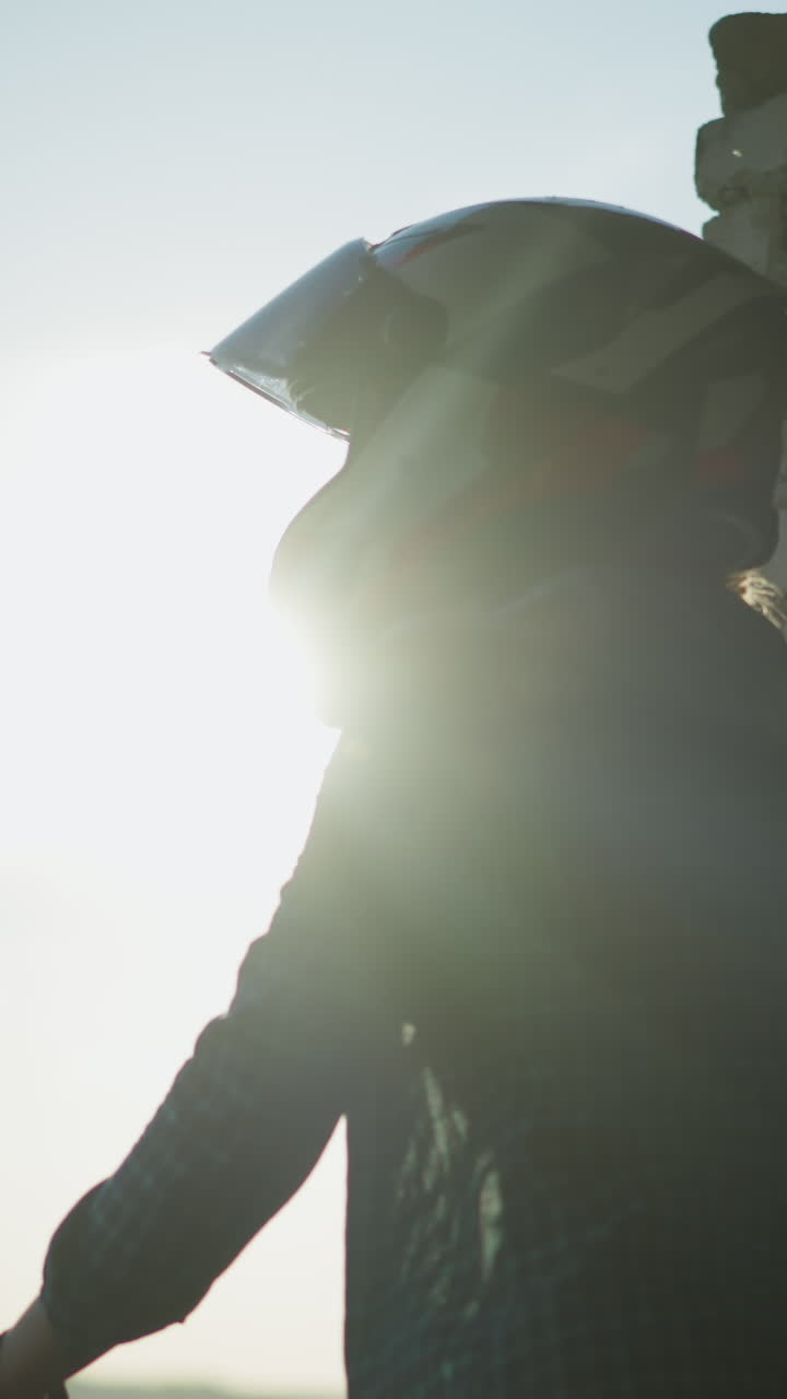 vista lateral de una dama de pie junto a una ventana de un viejo edificio, su mano descansando en la repisa, mientras mira hacia la distancia