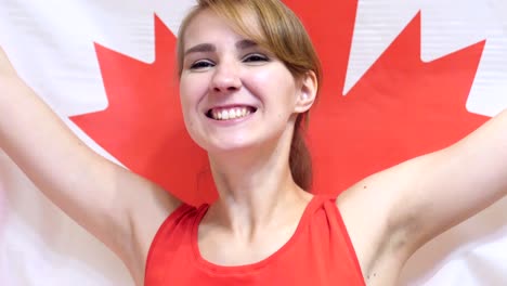 joven canadiense celebrando mientras sostiene la bandera de canadá en cámara lenta
