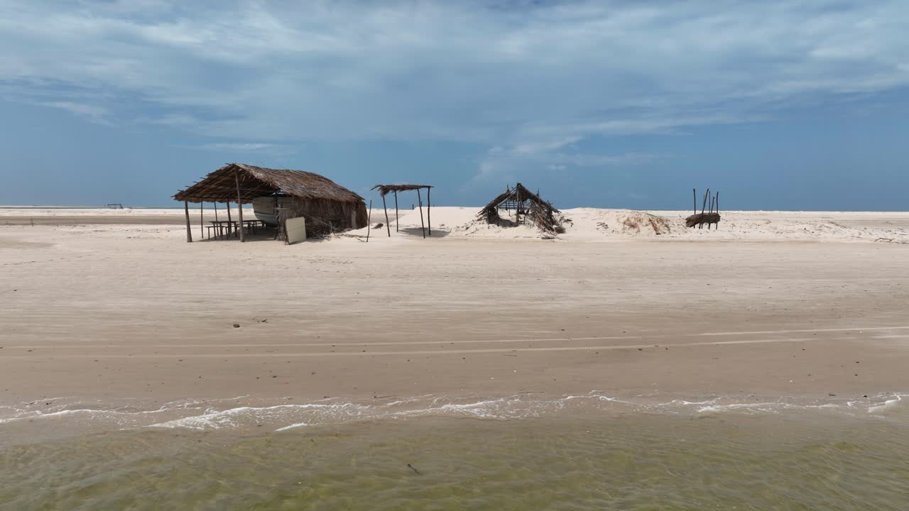 Wooden Shelter Structures at Sandy Parnaiba Riverbank, Left Track Shot