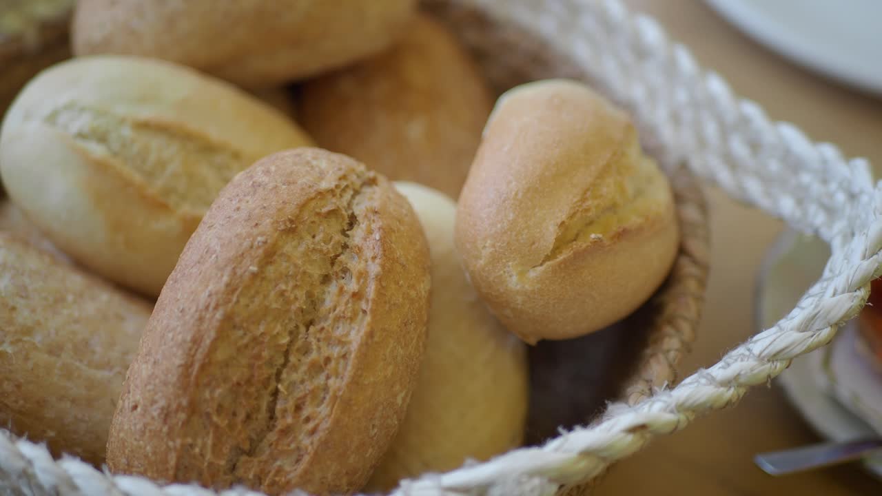 Fresh Bread Rolls in a Woven Basket with Tea