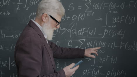 Professor Explaining Mathematical Equations on a Blackboard