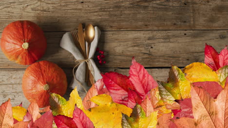 animation of autumn leaves over thanksgiving dinner place setting background